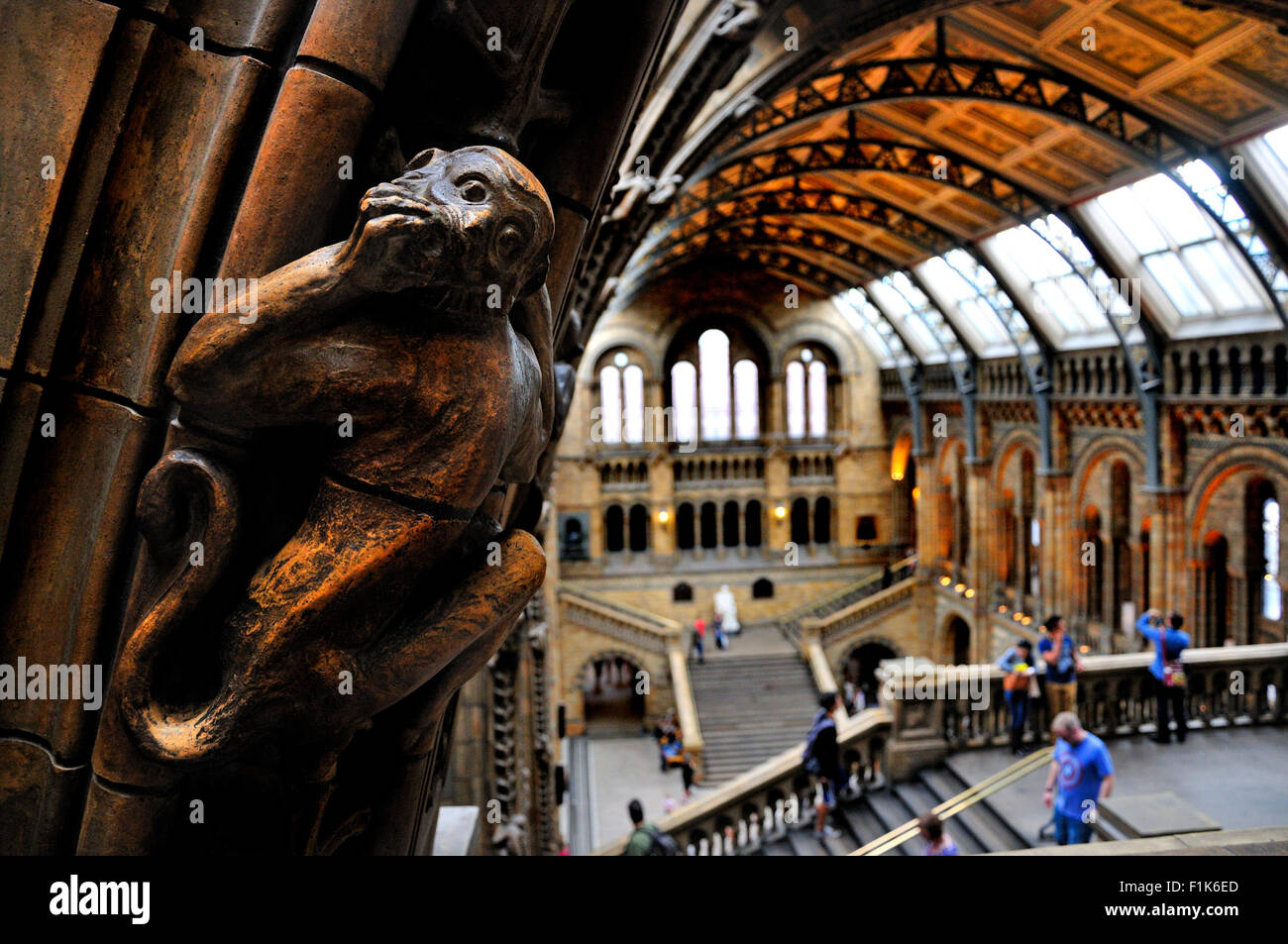 London, England, Vereinigtes Königreich. Natural History Museum, Kensington. Innenraum. Geschnitzten Stein Affe mit Blick auf den Central Hall Stockfoto