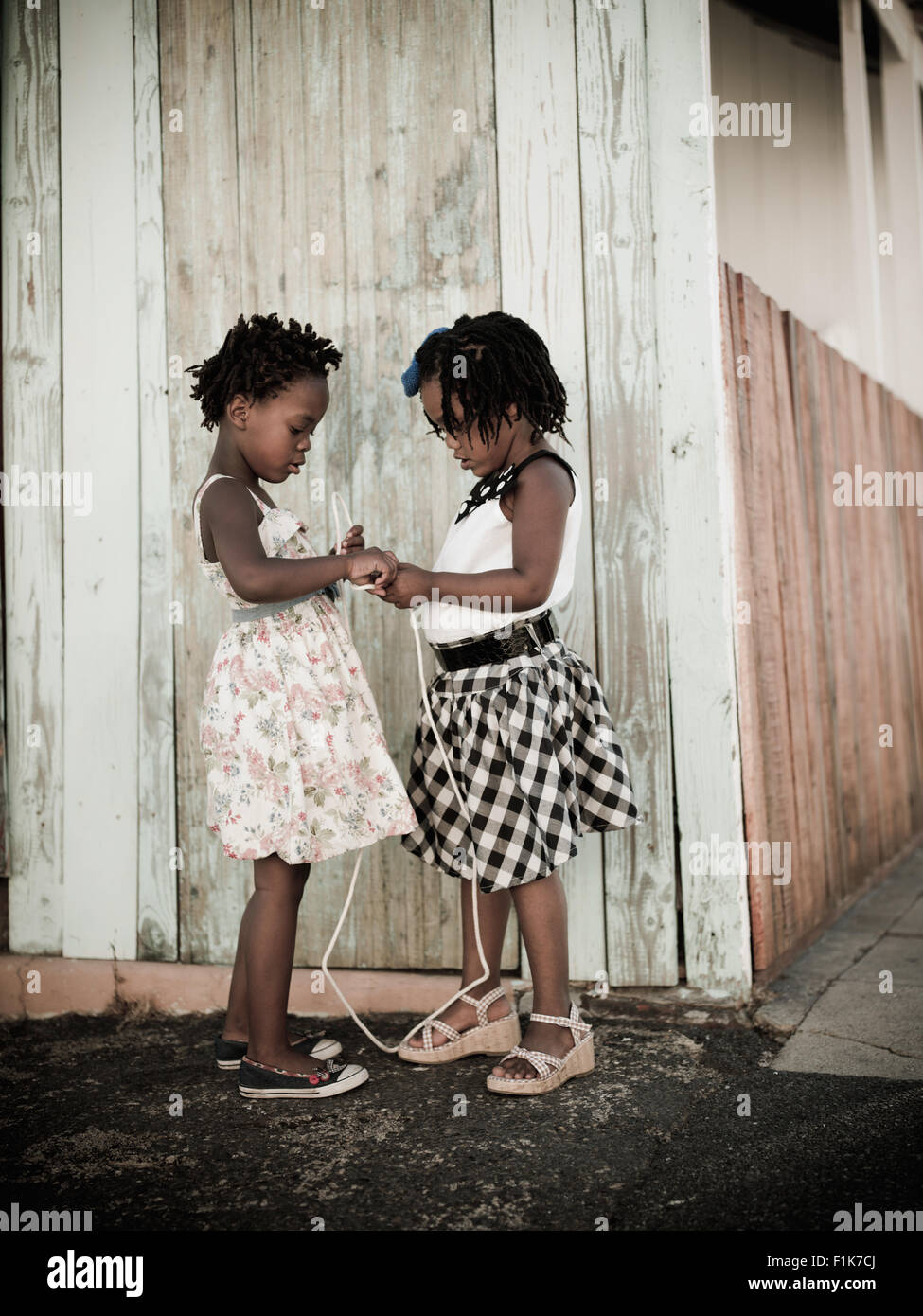 Zwei Mädchen spielen mit einem Stück Seil, Stadtteil Sophiatown, Cape Town, Western Cape Stockfoto