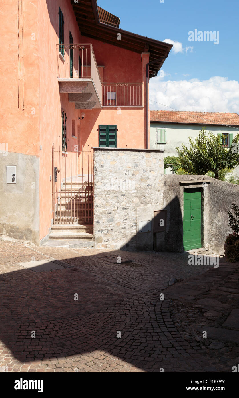 Häuser und gepflasterte Straße mit grünen Tür in Lenno, Comer See, Italien. Stockfoto