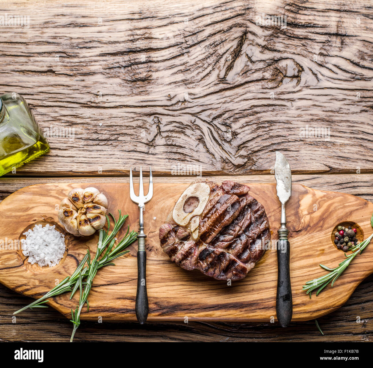 Rindersteaks mit Gewürzen auf einem Holztablett. Stockfoto