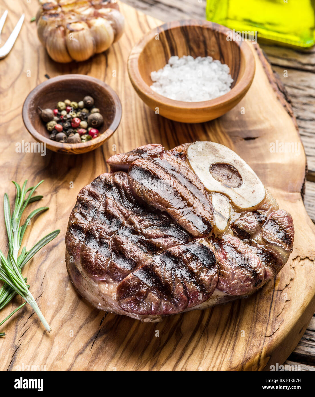 Rindersteaks mit Gewürzen auf einem Holztablett. Stockfoto