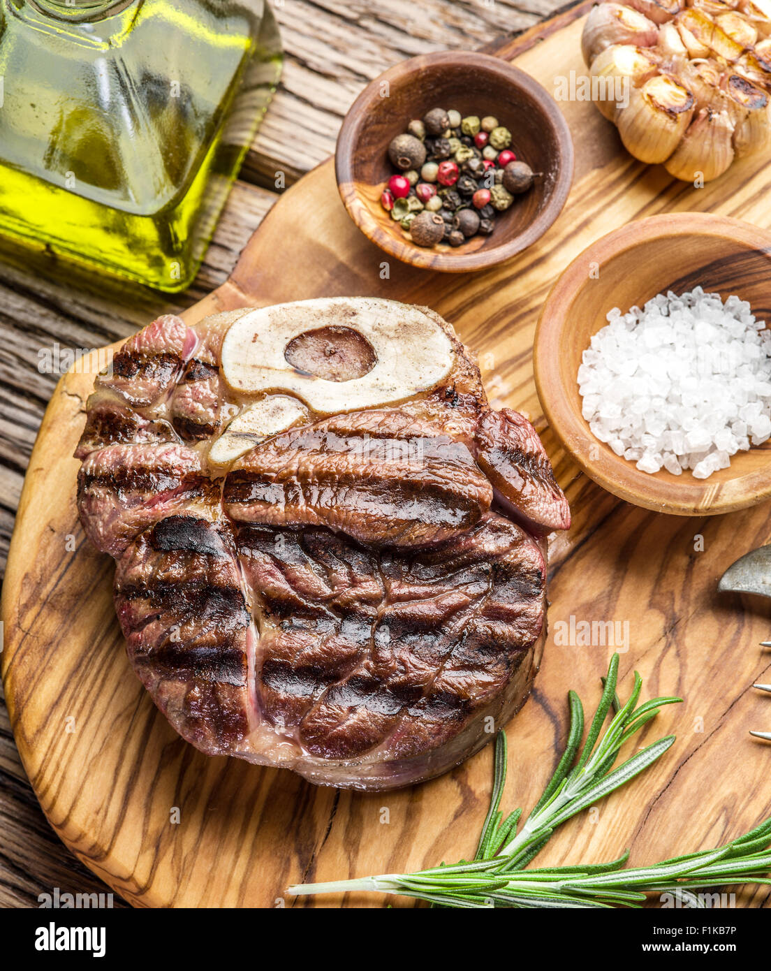 Rindersteaks mit Gewürzen auf einem Holztablett. Stockfoto