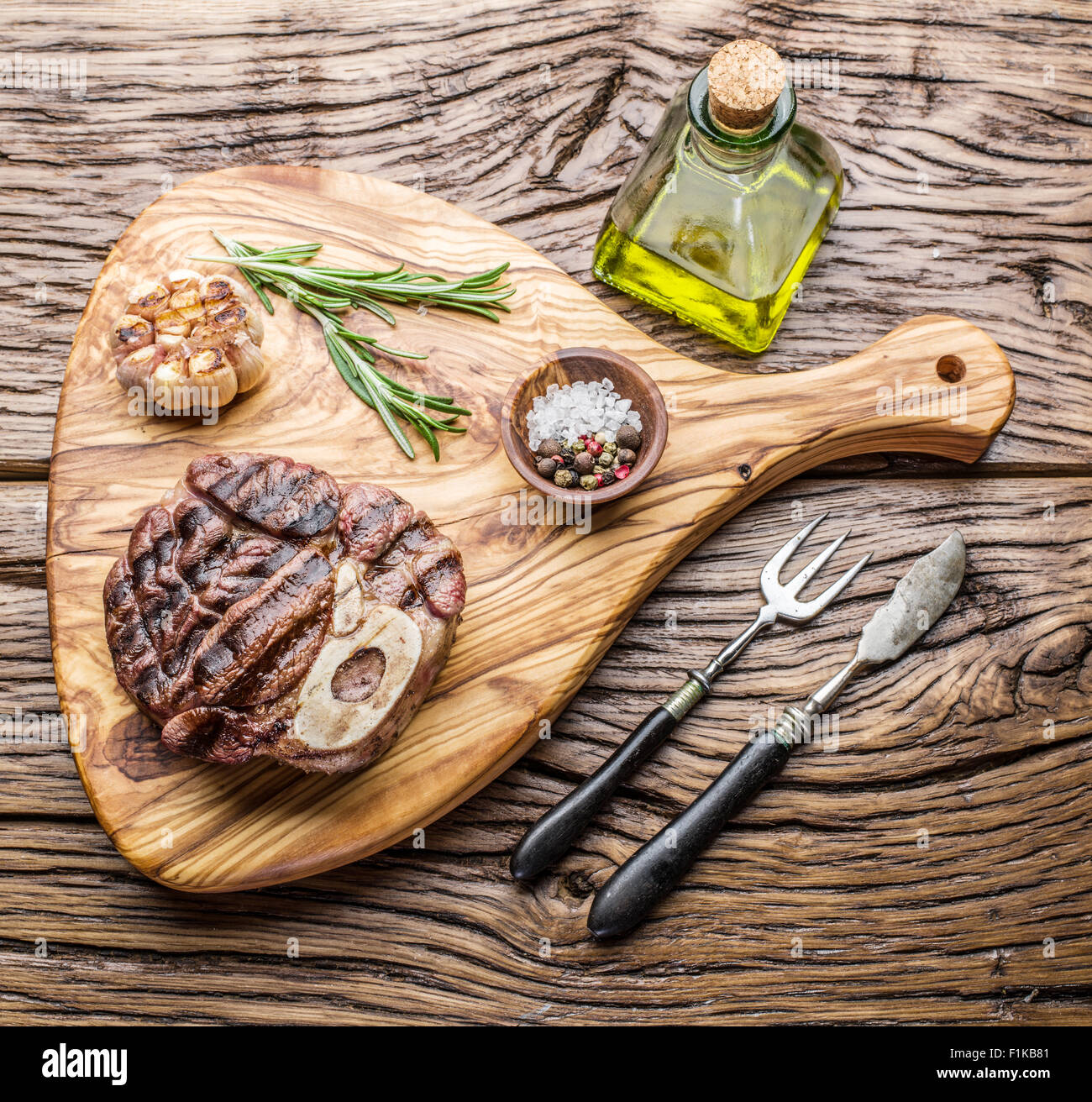 Rindersteaks mit Gewürzen auf einem Holztablett. Stockfoto