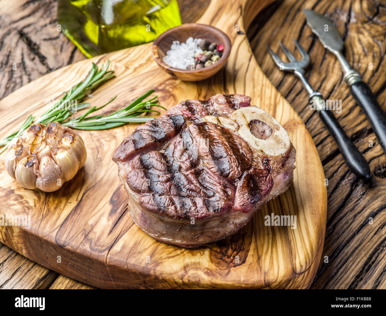Rindersteaks mit Gewürzen auf einem Holztablett. Stockfoto