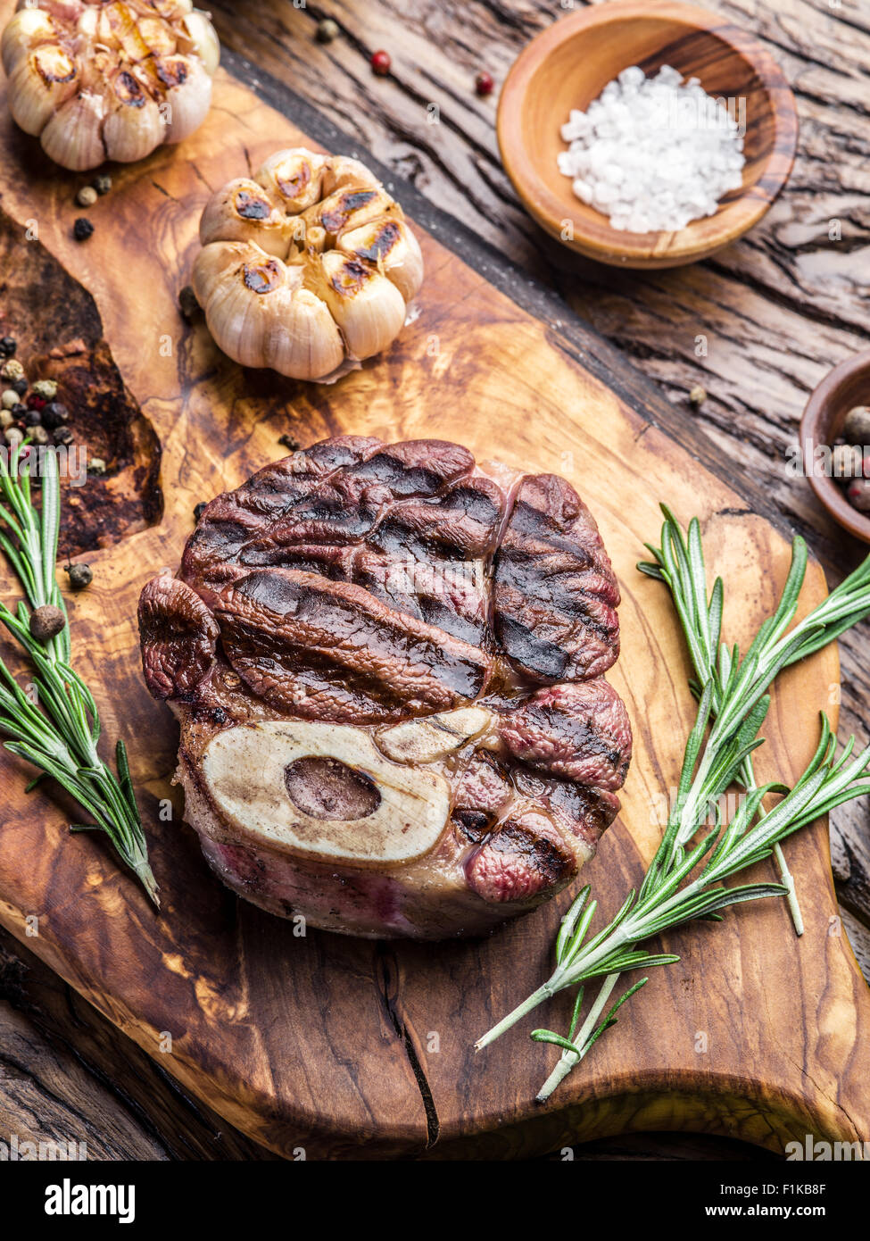 Rindersteaks mit Gewürzen auf einem Holztablett. Stockfoto
