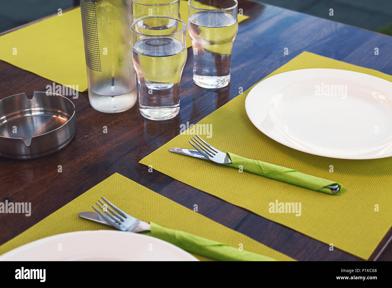 Leeren Sie Mittagszeit, Tisch für das Mittagessen vorbereitet, weißen Teller und Gläser Wasser. Stockfoto