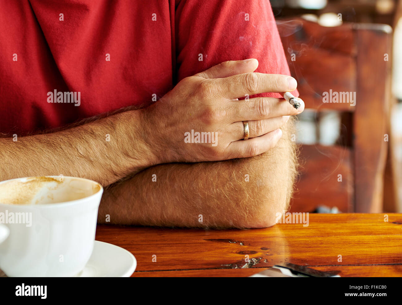Die Hand des Mannes mit einer Zigarette und eine Tasse Kaffee Stockfoto