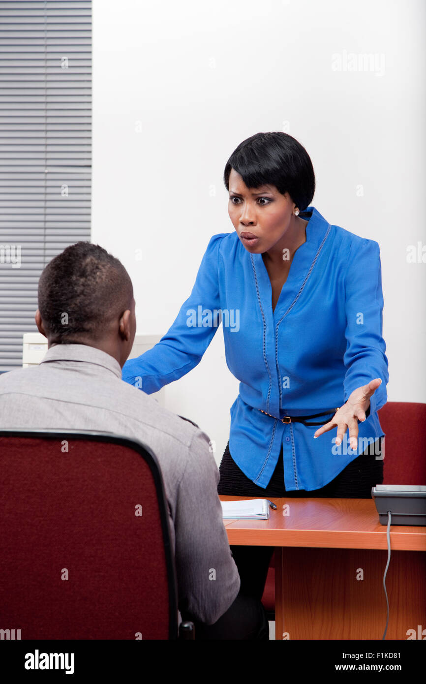Eine schwarze Managerin Disziplinierung eines Mitarbeiters Stockfoto