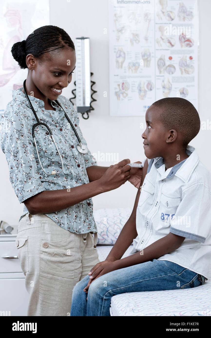 Arzt untersuchen männlichen afrikanischen Kindes in ein Arztzimmer Stockfoto