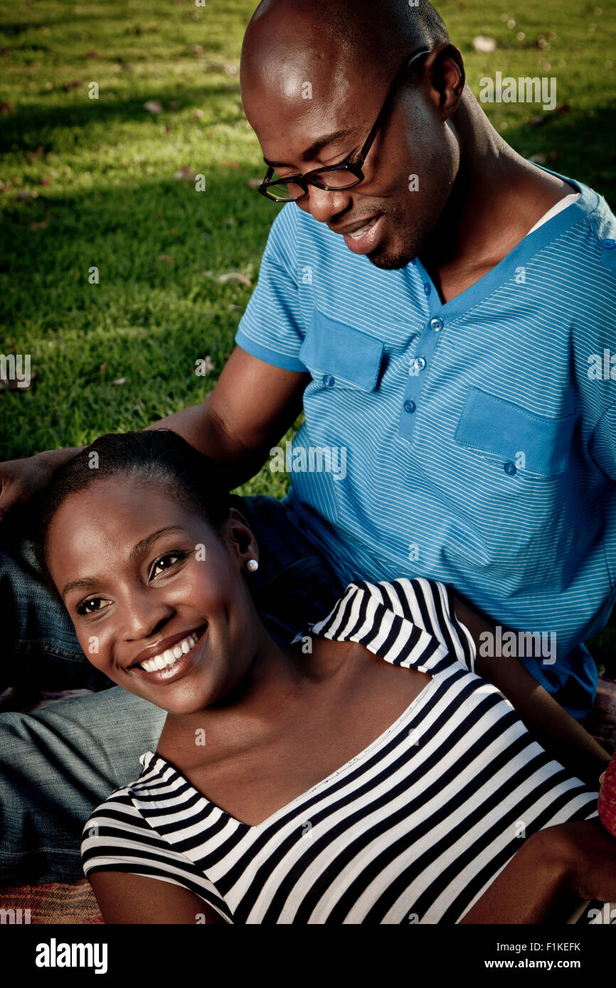 Junge afrikanische verheiratet paar sitzen zusammen in einem park Stockfoto