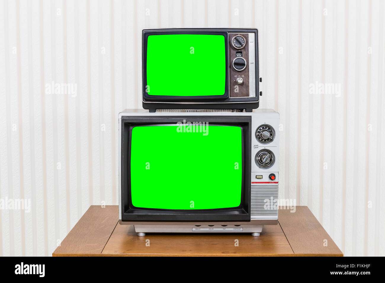 Vintage TV Stack auf alten Holztisch mit Chroma Key grüne Bildschirme Stockfoto