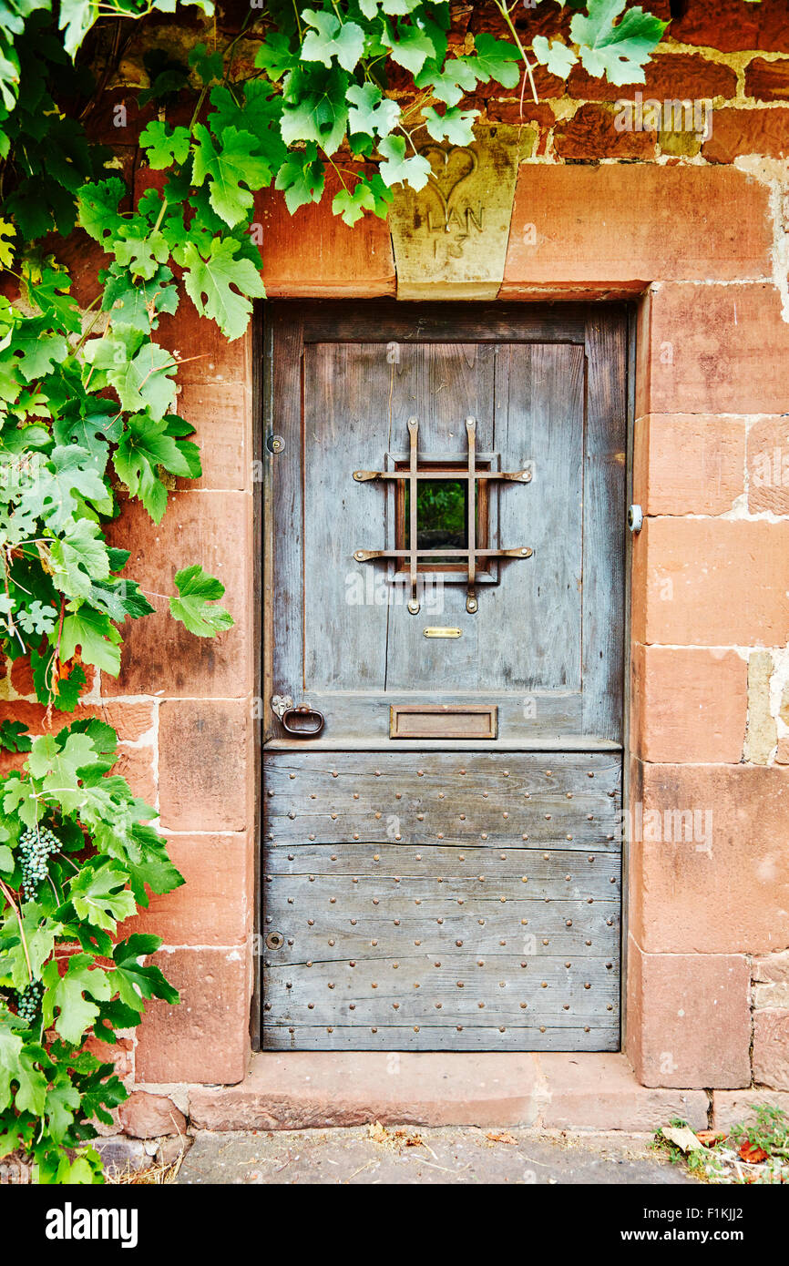 Blaue Tür in einem roten Steingebäude in Collonges-La-Rouge, Correze, Limousin, Frankreich. Stockfoto