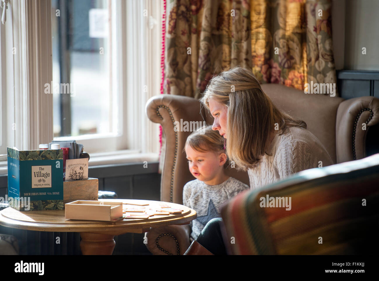 Eine Mutter spielt ein Spiel mit ihrer Tochter in einem Pub UK Stockfoto