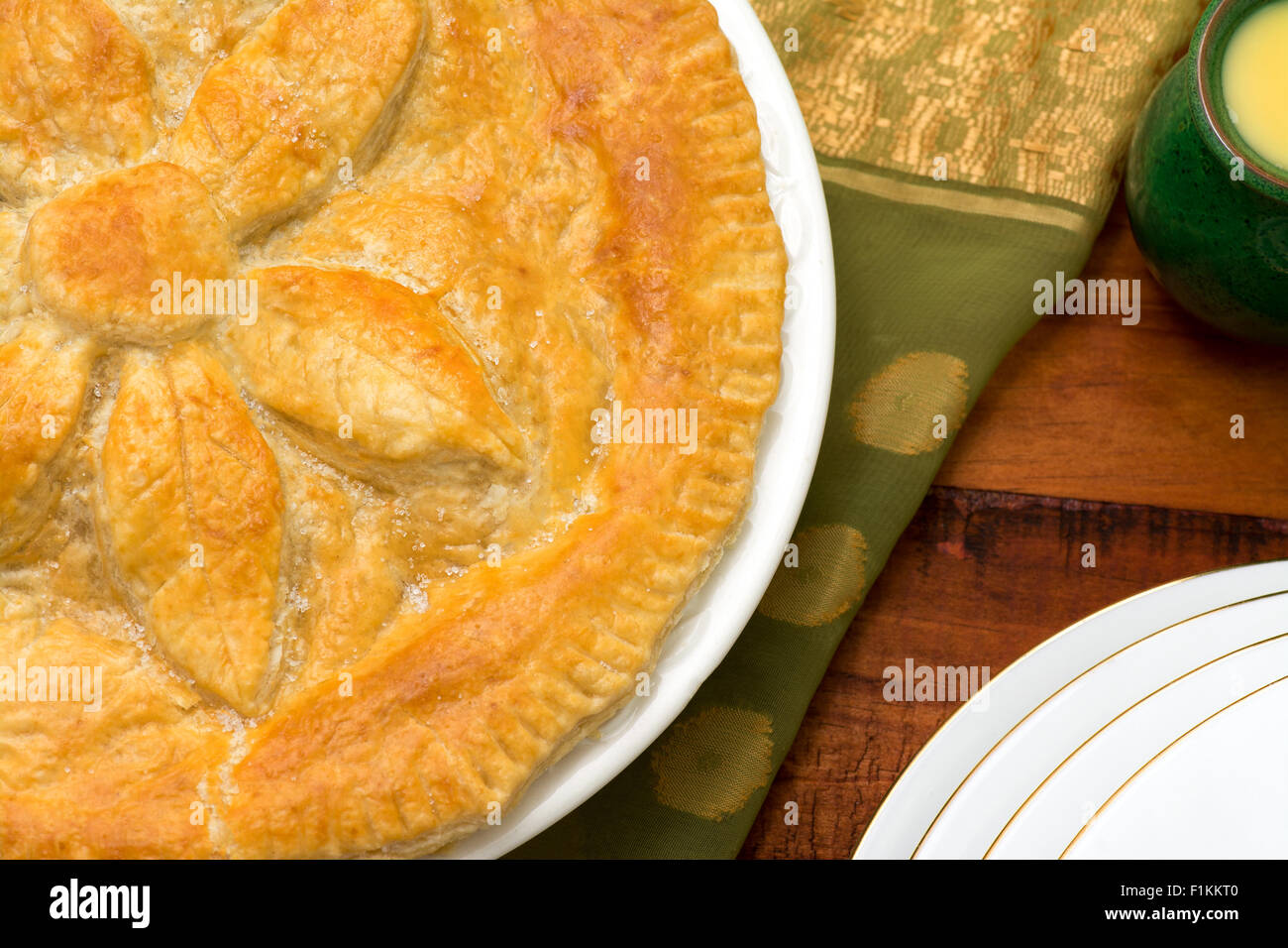 Ganze Apfelkuchen mit einem Krug Pudding und servieren Teller Tiefenschärfe. Platz für text Stockfoto