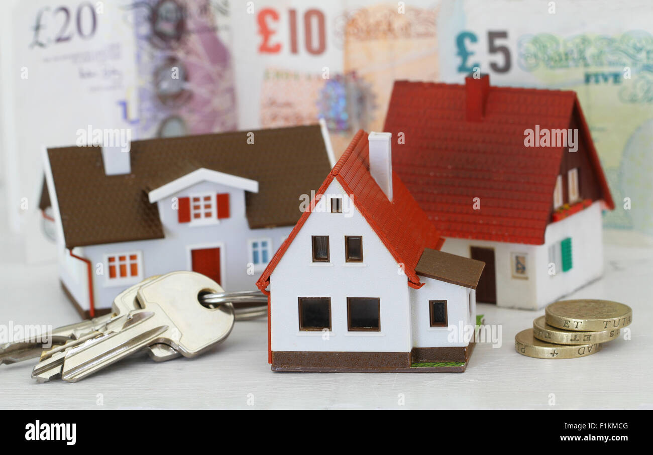 Modell Häuser und Tasten mit britischen Pfund im Hintergrund Stockfoto