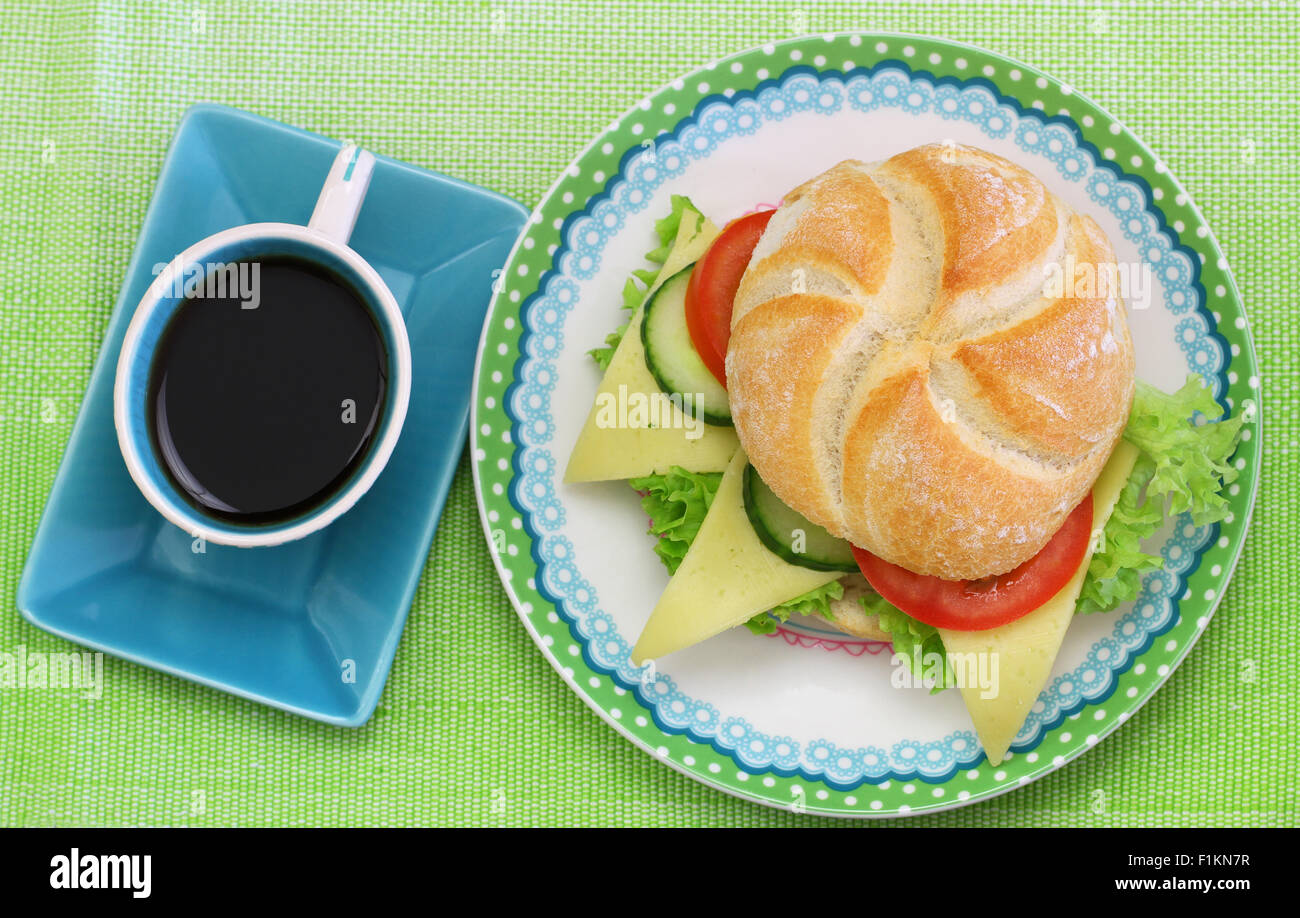 Käse-Brötchen mit Salat, Tomate und Gurke mit Tasse Kaffee Stockfoto