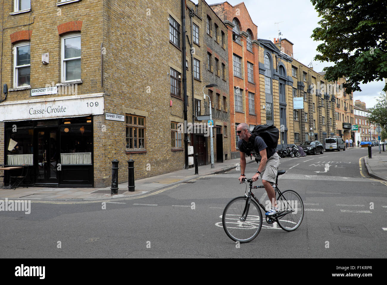 Männliche Radfahrer drehen Ecke vorbei Casse-Rolle auf dem Fahrrad Radfahren in Bermondsey Street, Southwark, South London UK KATHY DEWITT Stockfoto