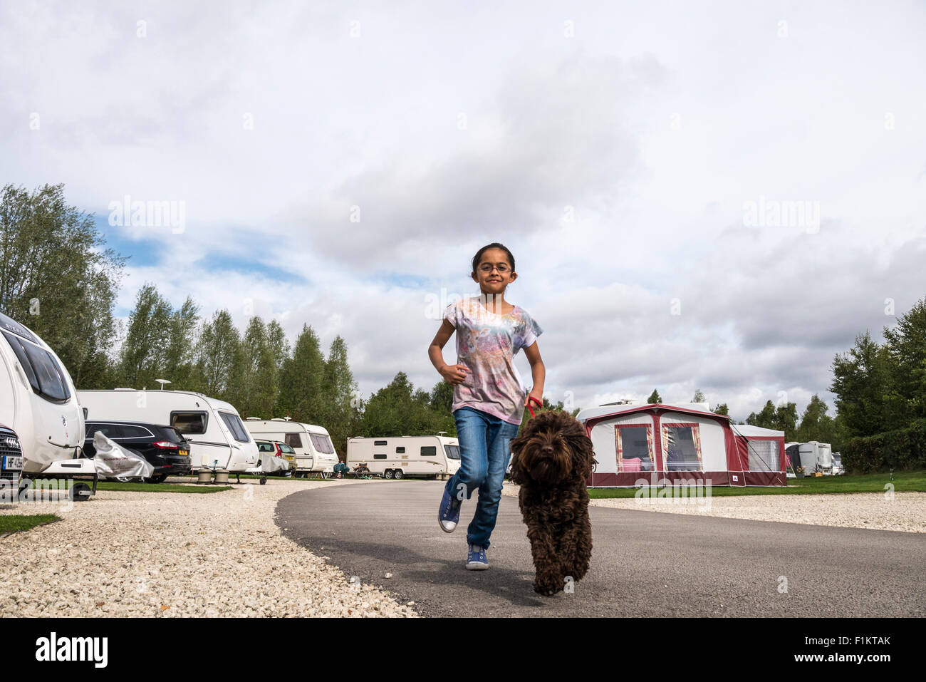 Mädchen mit ihrem Hund in einem Wohnwagenpark, Peak District, UK Stockfoto