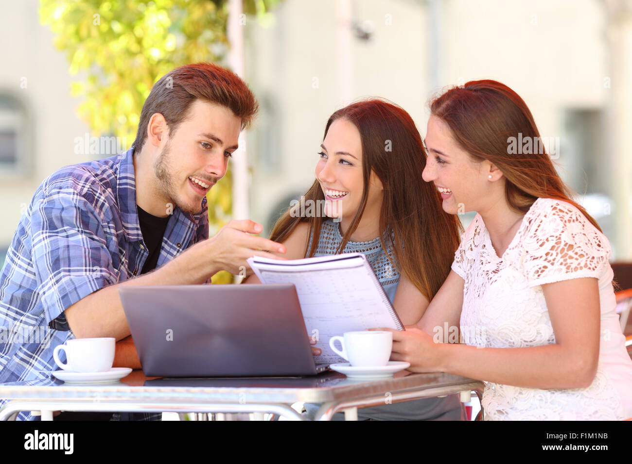 Drei Studenten studieren und lernen in einem Café mit einem Laptop und Notizen Stockfoto