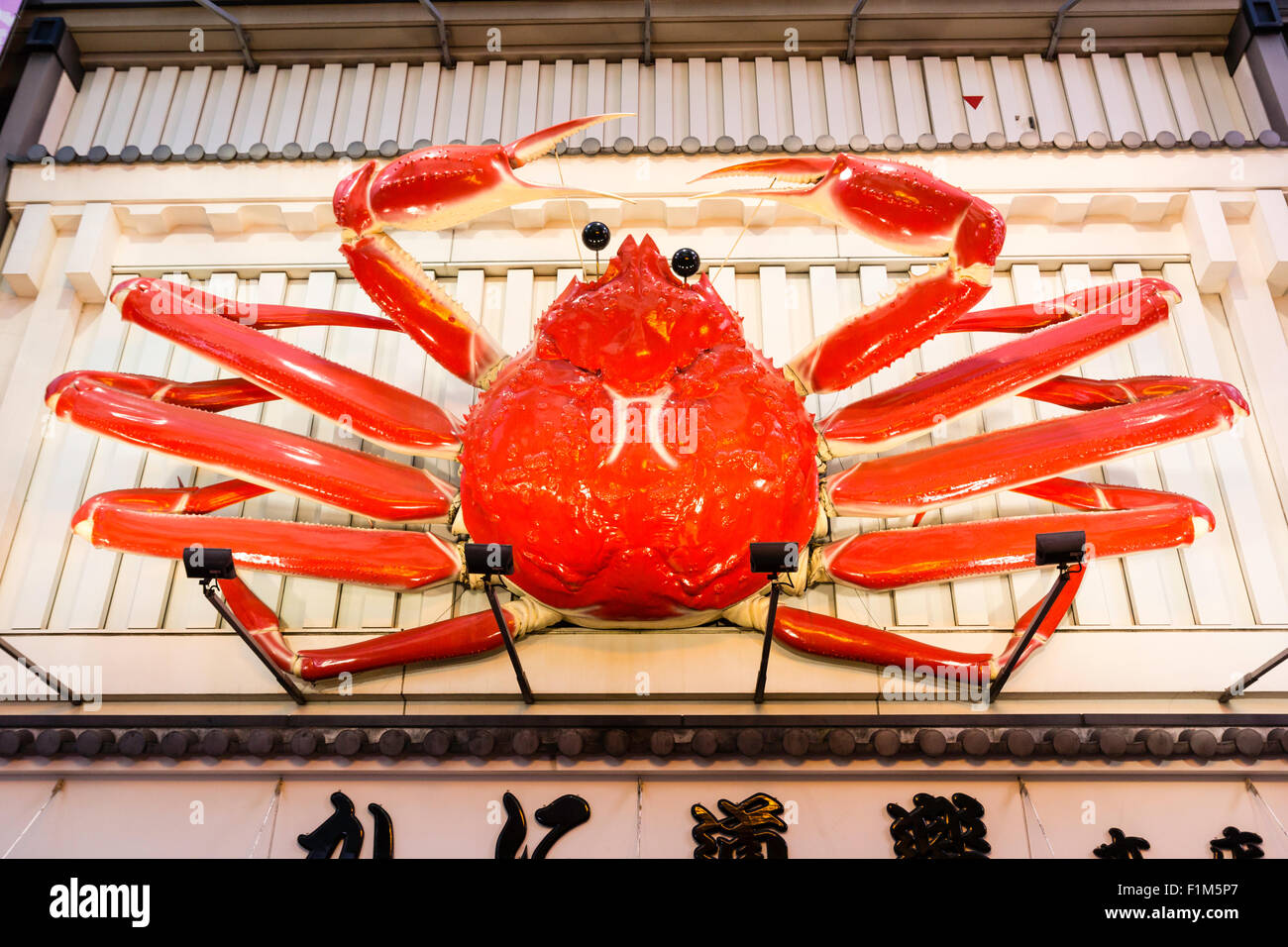 Osaka, Dotonbori. Die Außenseite des berühmten Crab Restaurant, Kani Doraku, mit riesigen mechanischen orange Crab über dem Eingang. Nacht Zeit, Zeichen beleuchtet. Stockfoto