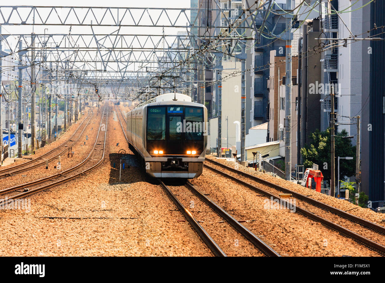 Japanische Eisenbahnen Pendler Zug nähert sich auf vier Spuren zwischen Nishinomiya und Shukugawa Stationen. Stockfoto