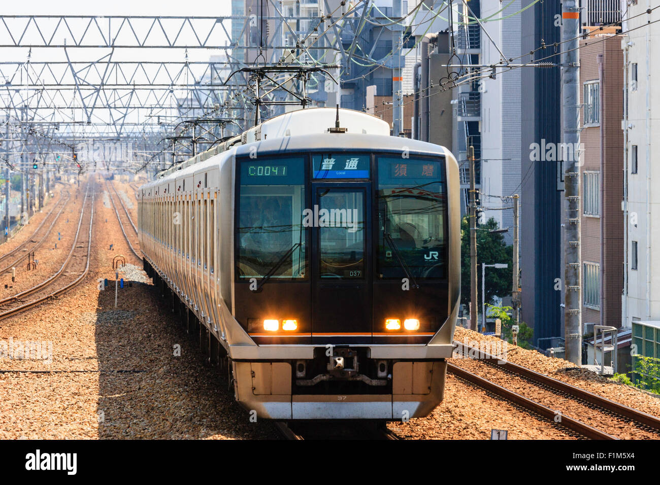 Japanische Eisenbahnen Pendler Zug nähert sich auf vier Spuren zwischen Nishinomiya und Shukugawa Stationen. Stockfoto
