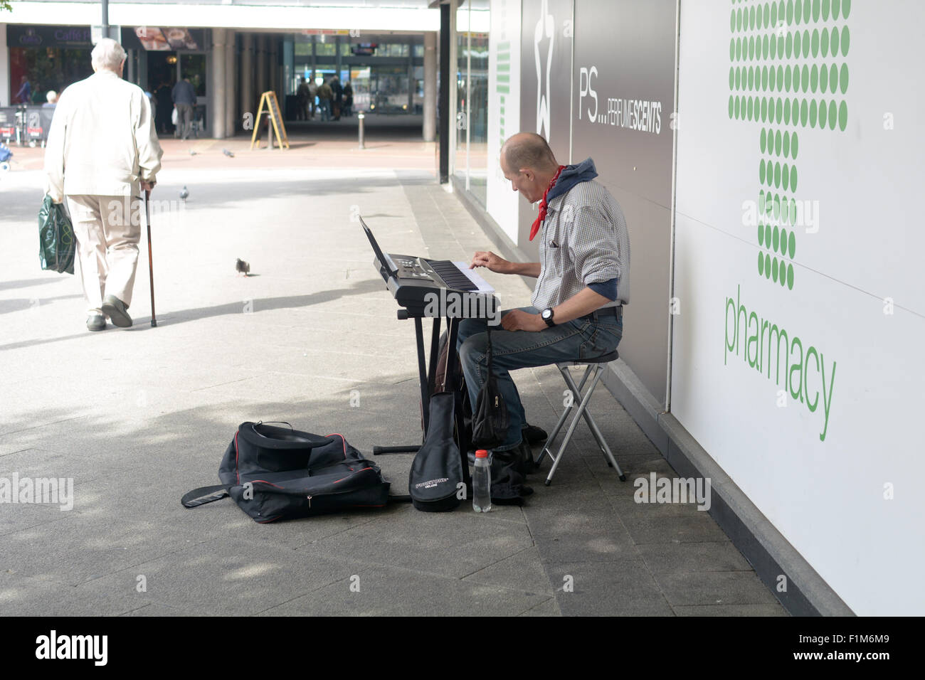 Man spielt eine Tastatur mit einer Hand als Straßenmusikant vor Geschäft in Bedford, Bedfordshire, England Stockfoto