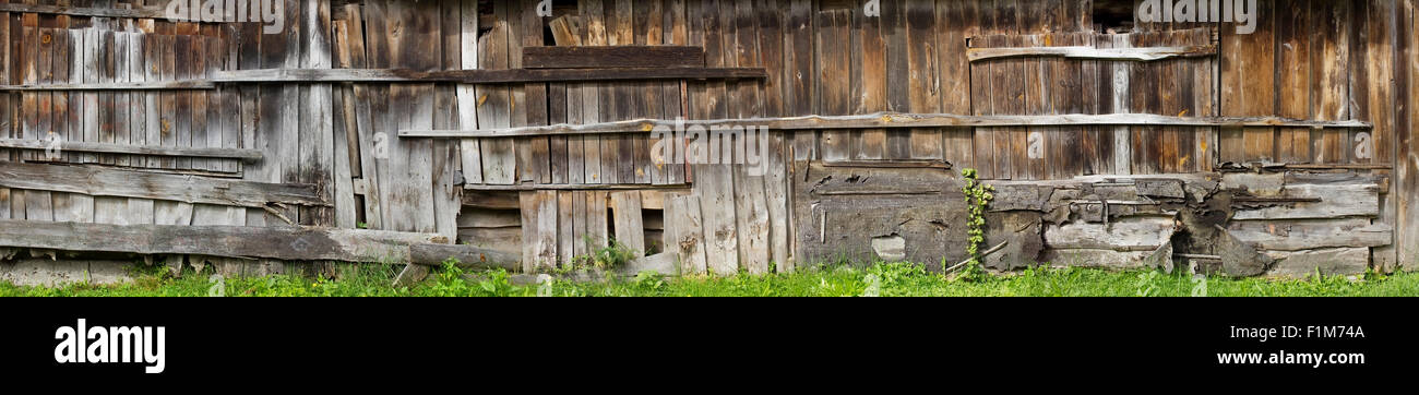 Wand des sehr langen ländlichen Holzschuppen. Die Bretter morsch und kaputt. Die zerstörte nicht benutzte Gebäude. Panorama aus mehreren Bildern Stockfoto