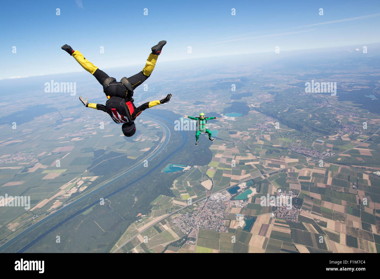 Fallschirmspringer Team trainiert in den blauen Himmel zusammen. Die Frau ist Kopf fliegen und das Männchen in der Sit-Lage von 125 km/h. Stockfoto