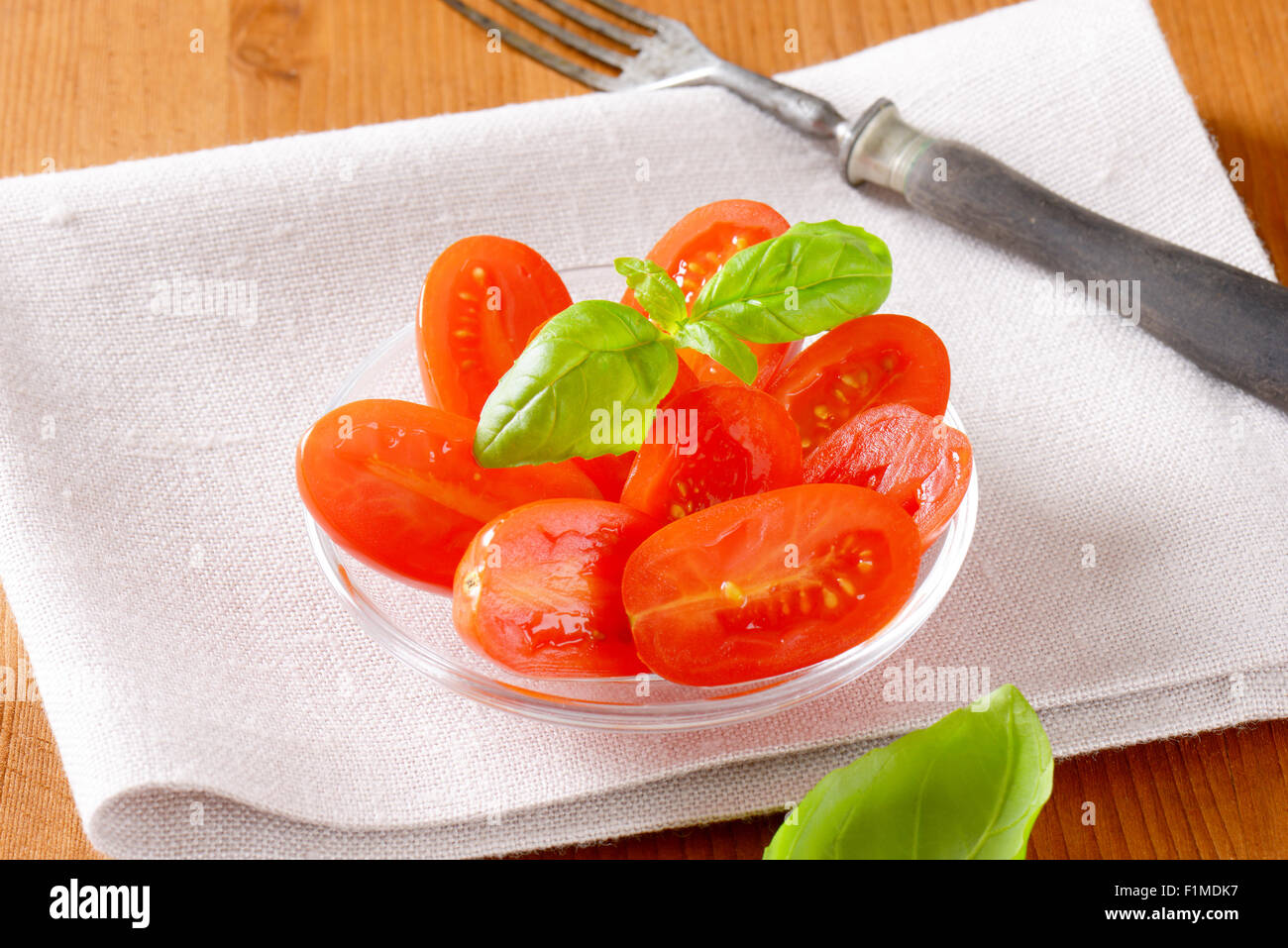 Tomatensalat mit Basilikum auf weißen Tischset Stockfoto