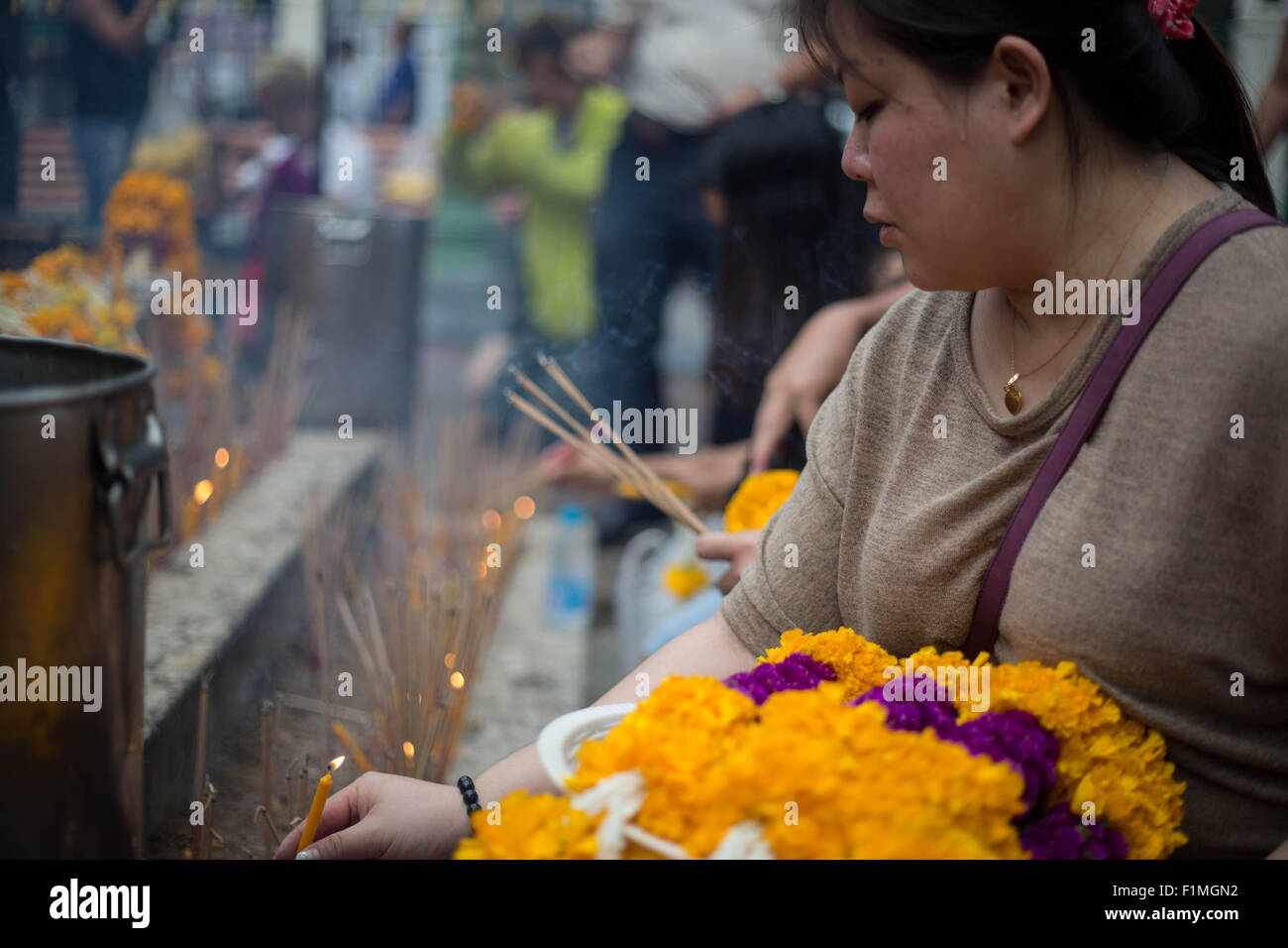 Bangkok, Thailand. 4. Sep, 2015. Eine Frau eine Kerze vor der Brahma-Statue an der Erawan-Schrein im Zentrum von Bangkok am 4. September 2015, nach der Wiederherstellung der beschädigten Statue vom 17. August Bombenanschlag die 20 Menschen getötet und verletzt mehr als Hunderte. Bildnachweis: Guillaume Payen/ZUMA Draht/Alamy Live-Nachrichten Stockfoto