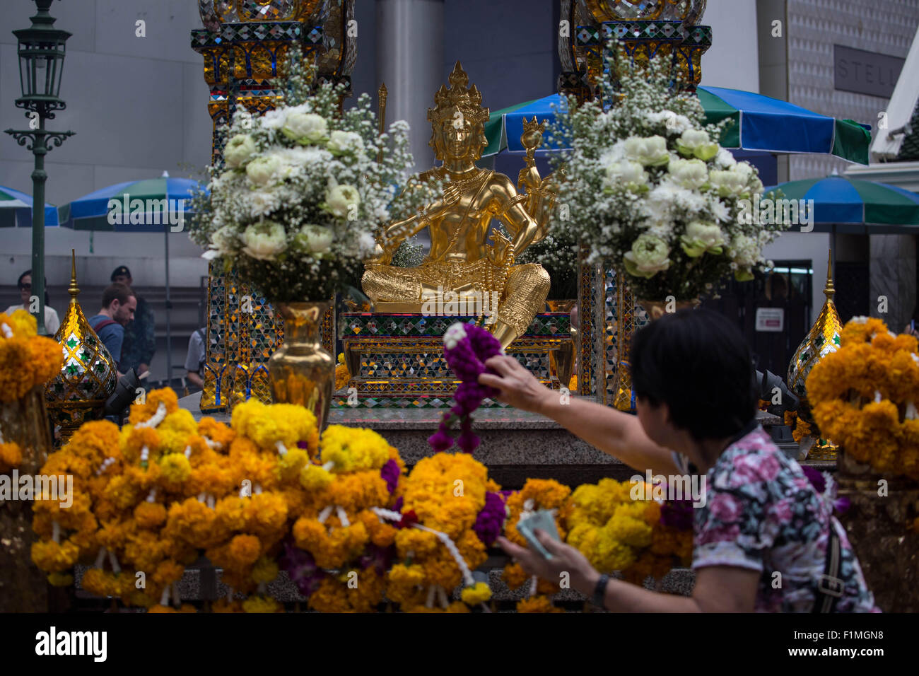 Bangkok, Thailand. 4. Sep, 2015. Eine Frau legte Blumen vor der Brahma-Statue an der Erawan-Schrein im Zentrum von Bangkok am 4. September 2015, nach der Wiederherstellung der beschädigten Statue vom 17. August Bombenanschlag die 20 Menschen getötet und verletzt mehr als Hunderte. Bildnachweis: Guillaume Payen/ZUMA Draht/Alamy Live-Nachrichten Stockfoto