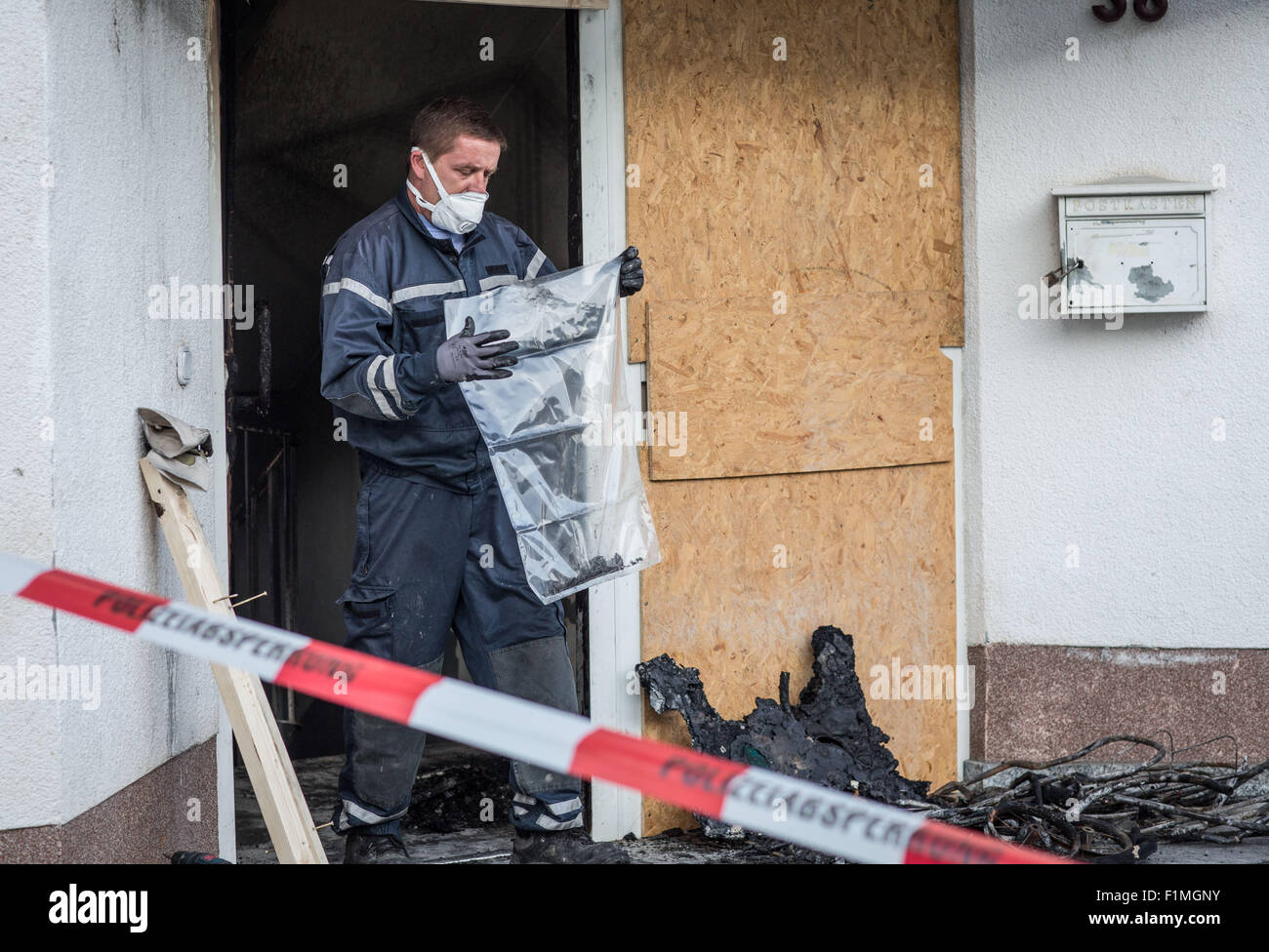 Heppenheim, Deutschland. 4. Sep, 2015. Ein Polizist untersucht die Räumlichkeiten einer Unterkunft für Asylbewerber Spurensuche nach ein Brand im Treppenhaus des Gebäudes in Heppenheim, Deutschland, 4. September 2015 erloschen war. Ein Polizei-Sprecher erklärte, dass ein Bewohner sich durch einen Sprung aus dem zweiten Stock ins freie gerettet, entstehen Verletzungen zu trennen. Weitere Bewohner erlitten Vergiftungen Leight Rauch. Die Ursache des Brandes blieb bisher noch unbekannt. Foto: Frank Rumpenhorst/Dpa/Alamy Live News Stockfoto