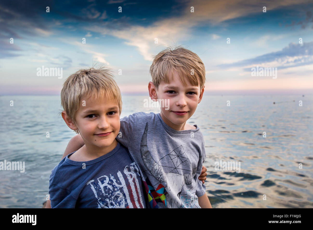zwei junge Brüder in Umarmung am Ufer des Meeres Stockfoto