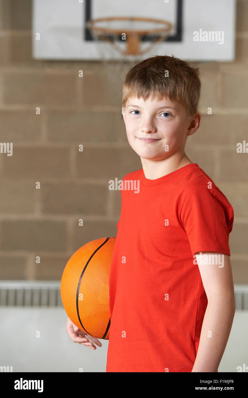 Porträt eines jungen Basketball In Turnhalle hält Stockfoto
