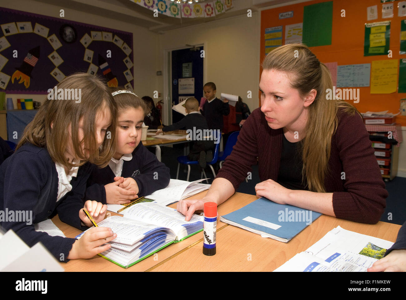 Grundschullehrer helfen Schüler in der Klasse, London, UK. Stockfoto