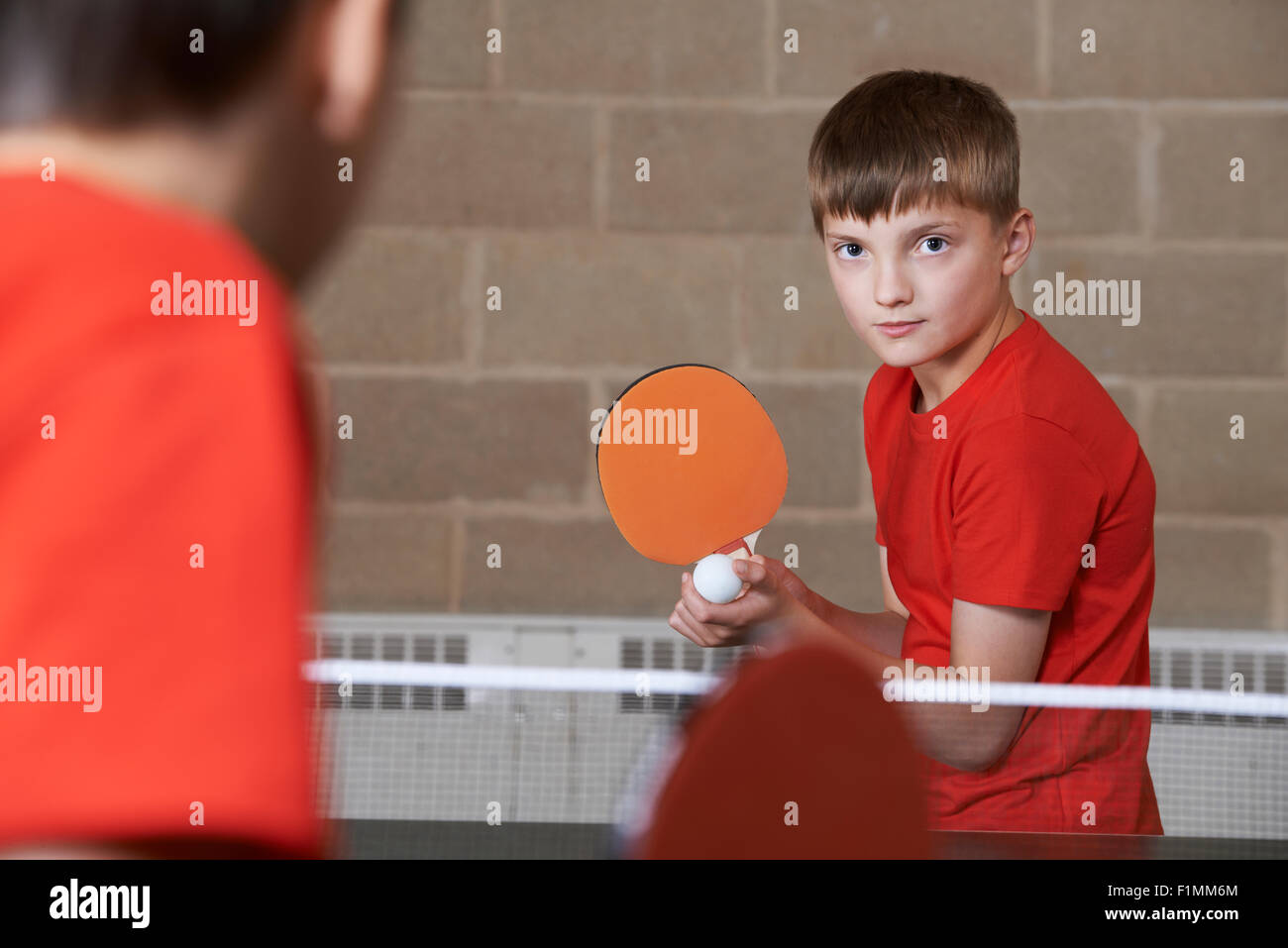 Zwei Jungs spielen Tischtennis Match In Turnhalle Stockfoto