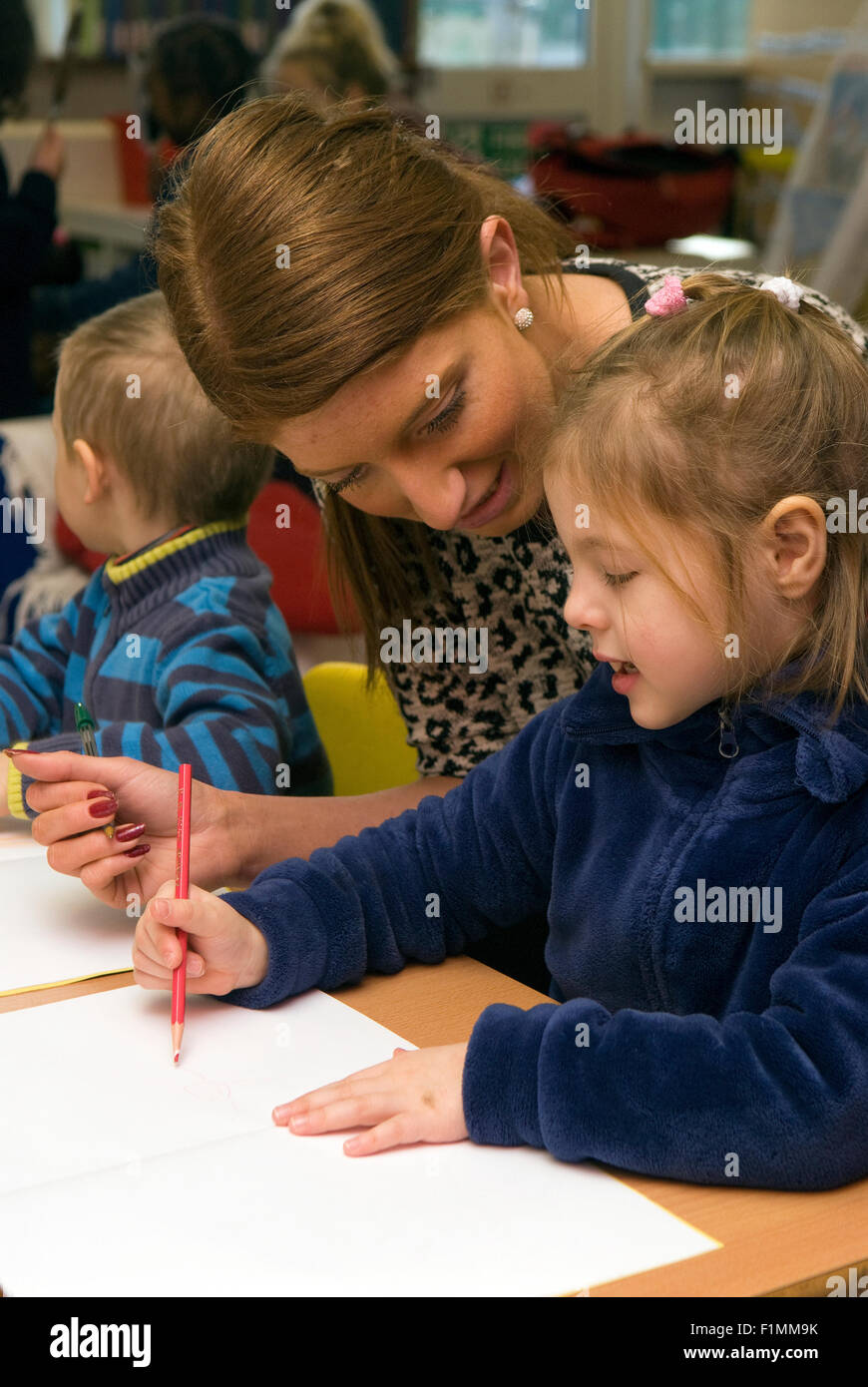 Grundschullehrerin, die Unterstützung der Schüler im Klassenzimmer, London, UK. Stockfoto