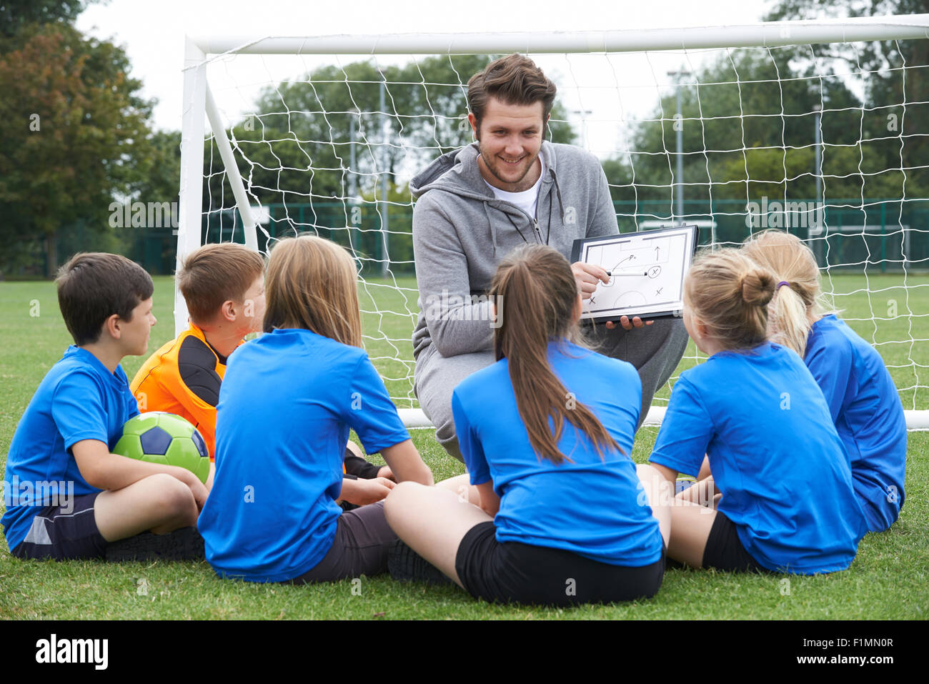 Trainer geben Teamsitzung zur Grundschule Fußballmannschaft Stockfoto