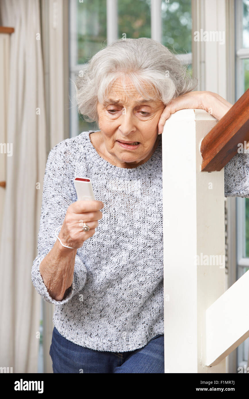 Unwohl Senior Woman Using Personenalarm zu Hause Stockfoto