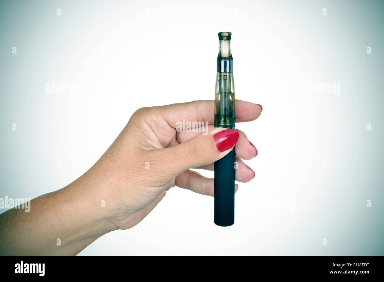 Nahaufnahme der Hand einer jungen Frau zeigt eine elektronische Zigarette, leichte Vignette hinzugefügt Stockfoto