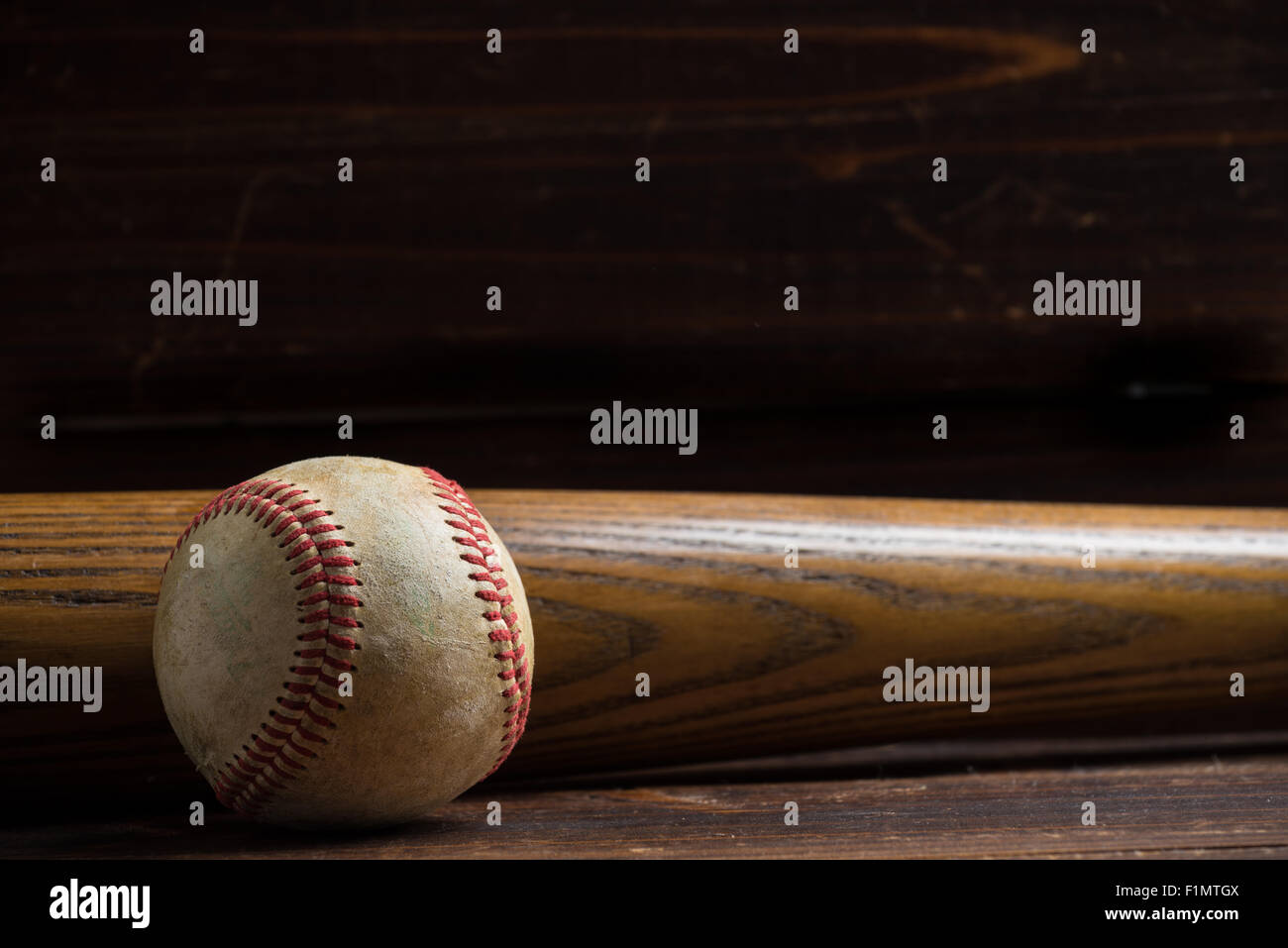 Baseball-Ausrüstung: hölzerne Schläger und Ball auf einem hölzernen Brett oder Bank Hintergrund Stockfoto
