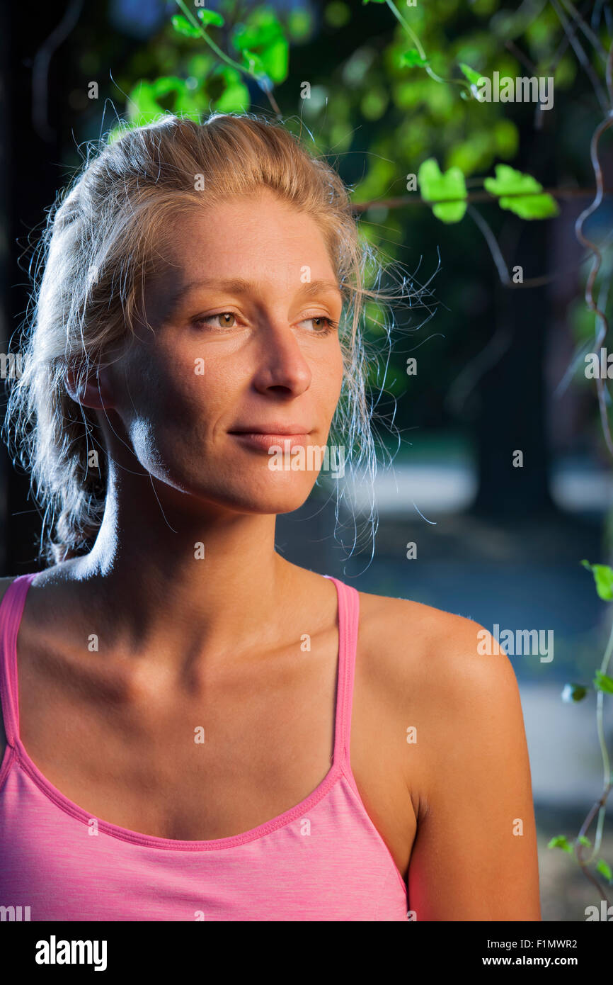 seitliche Kopf Porträt von einem lächelnden blonden Frau mittleren Alters in der Seite Fensterlicht Stockfoto