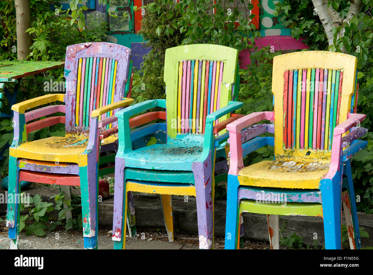 Bunt bemalte Stühle im Garten Stockfotografie - Alamy