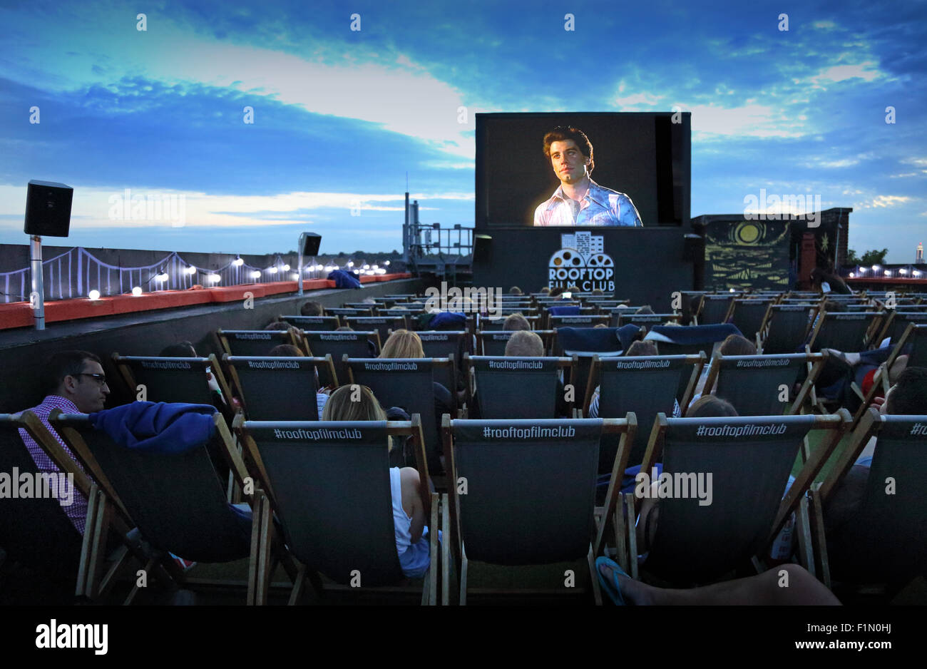 Das Freiluftkino auf dem Dach Peckhams Bussey Gebäude. Ein Publikum genießt John Travolta in Saturday Night Fever Stockfoto