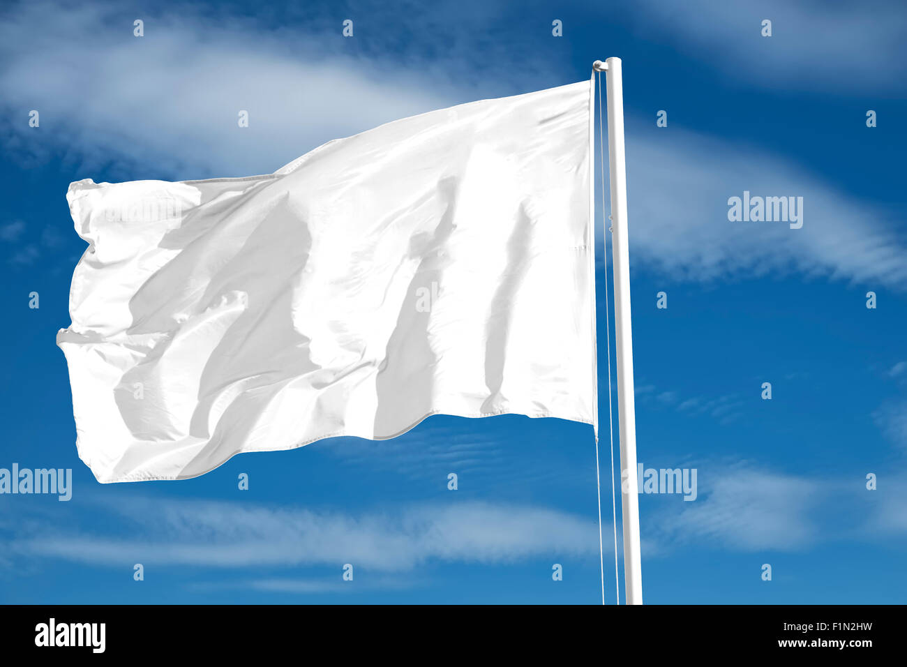 Leere weiße Flagge auf blauem Himmelshintergrund isoliert. Stockfoto