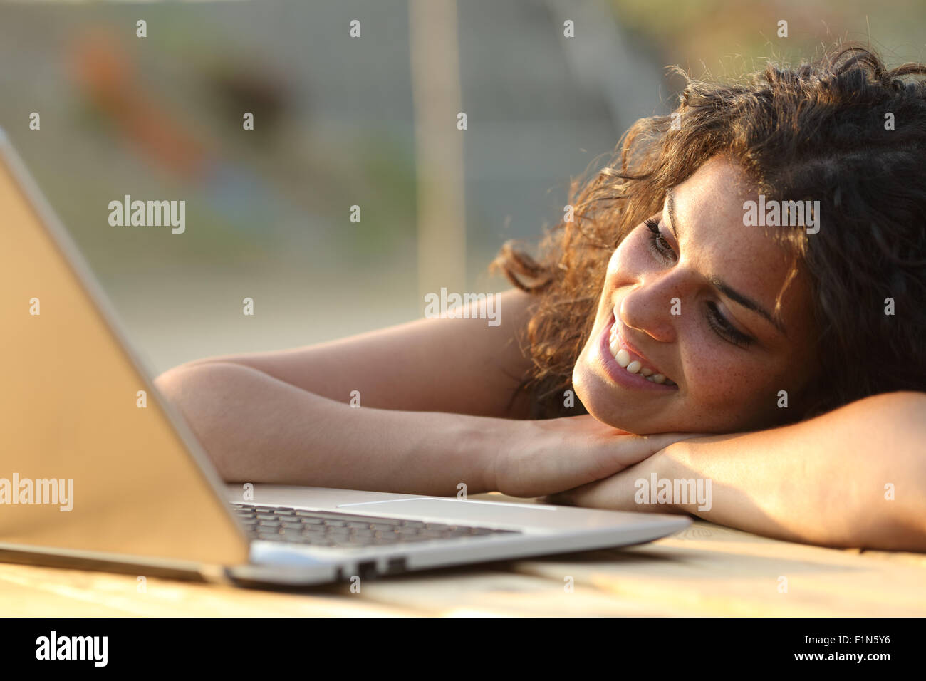 Nahaufnahme einer Frau beobachten Medien in einem Laptop in einem Park-Tabelle Stockfoto