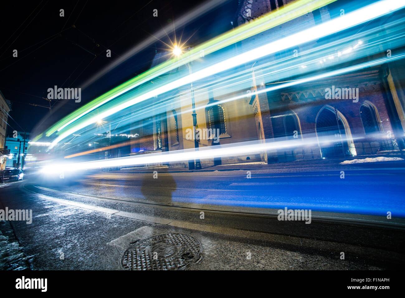 Ampel in Langzeitbelichtung. Beschleunigung der Straßenbahn und Autos in Krakau, Polen. Transport-Fotosammlung. Stockfoto