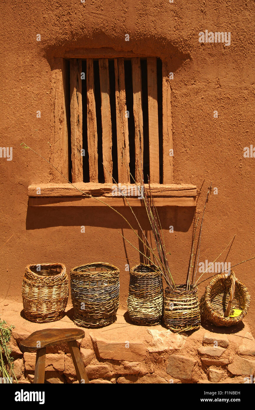 Baskets gegen und Adobe Wand handgemachte Körbe auf einem Felsvorsprung neben einer Adobe-Wand im El Rancho de Las Golondrinas in der Nähe von Santa Fe Stockfoto