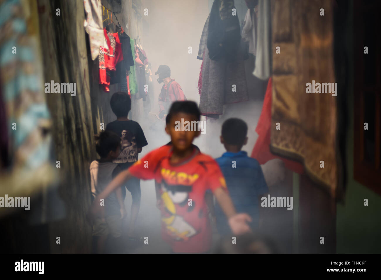 Kinder beobachten Moskitos, die in einem dicht besiedelten Viertel in Jakarta, Indonesien, beschlagen. Stockfoto
